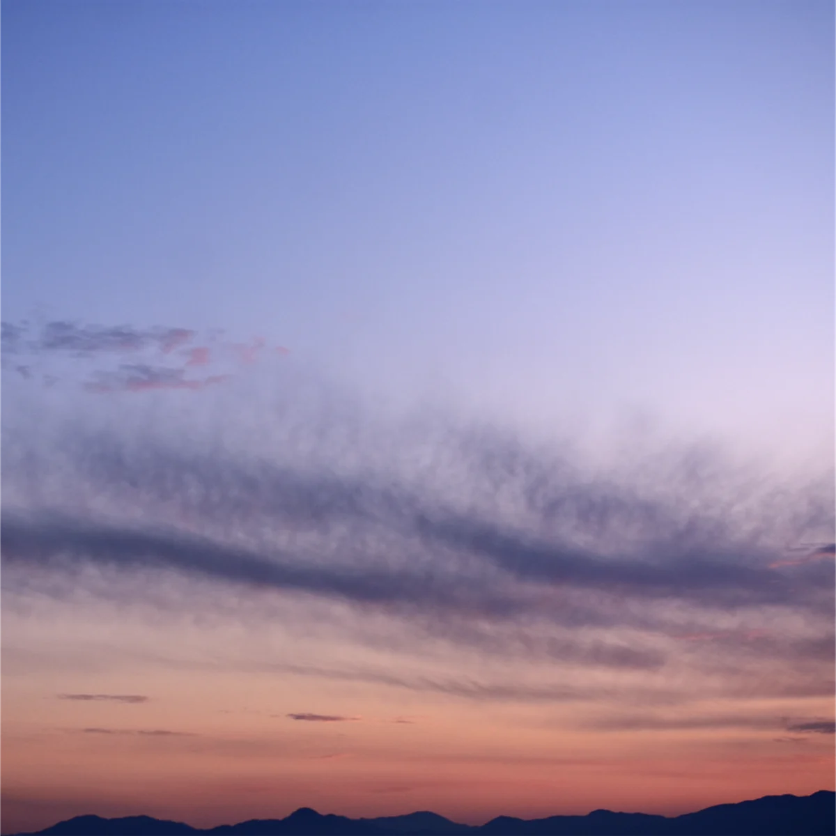 夕暮れの空の下に山並みが写っている