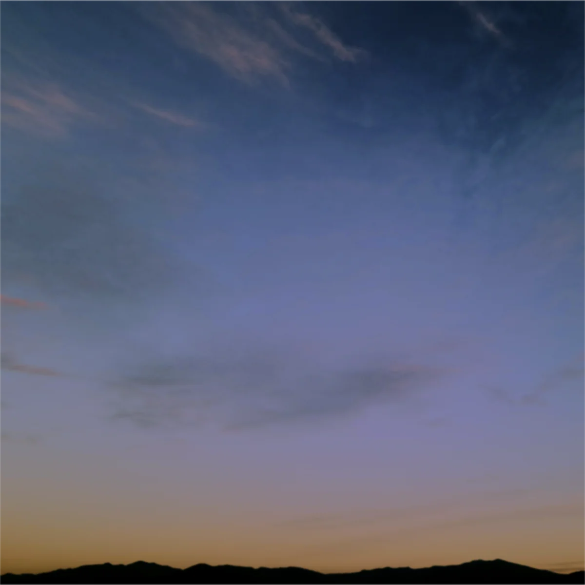 夕暮れの空の下に山並みが写っている