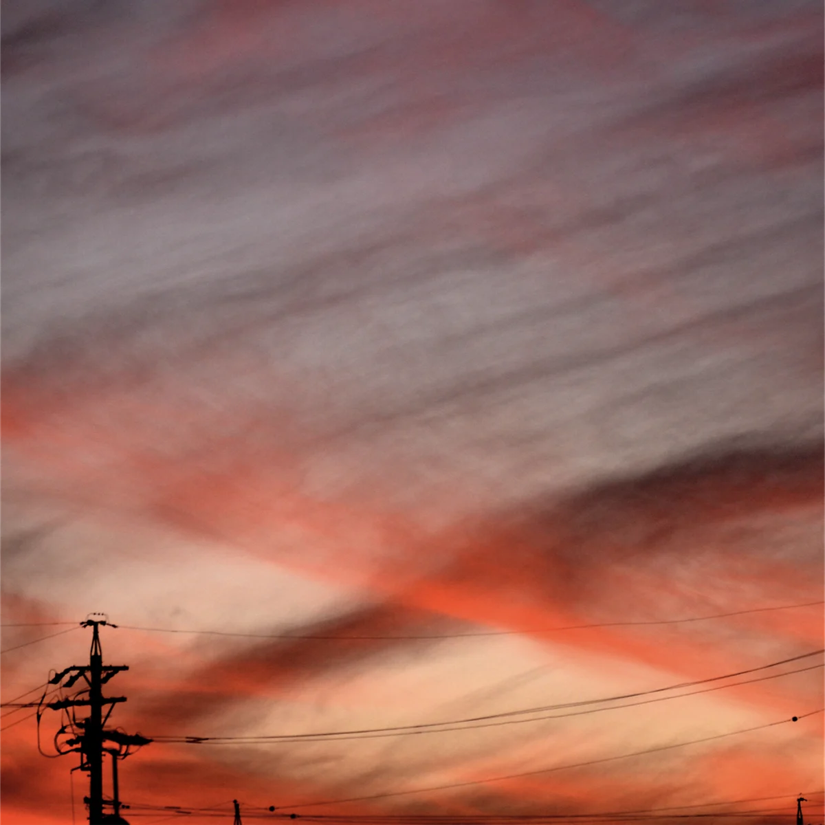夕空の雲が交差して朱色に色づいている