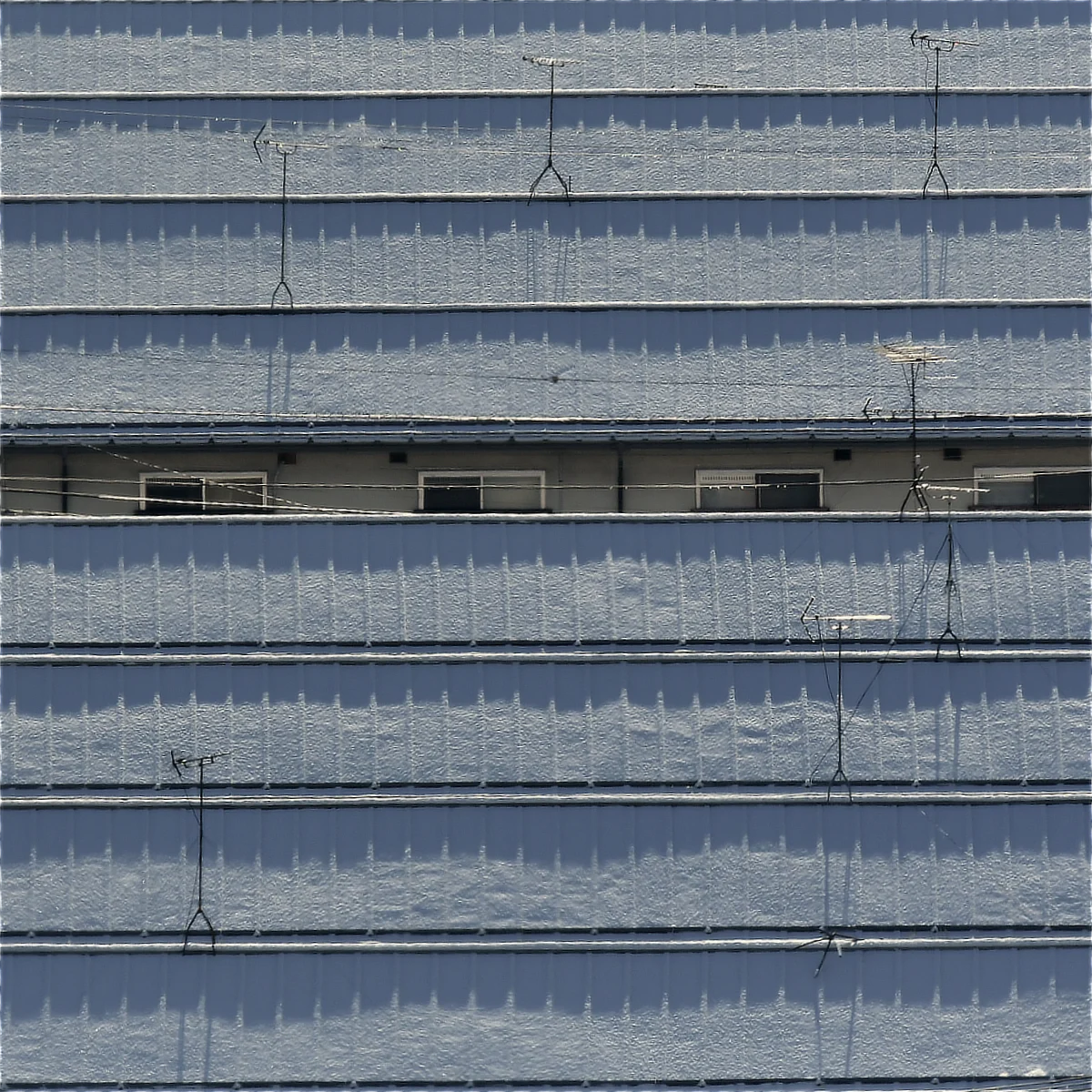 集合住宅の屋根に薄く雪が積もっている