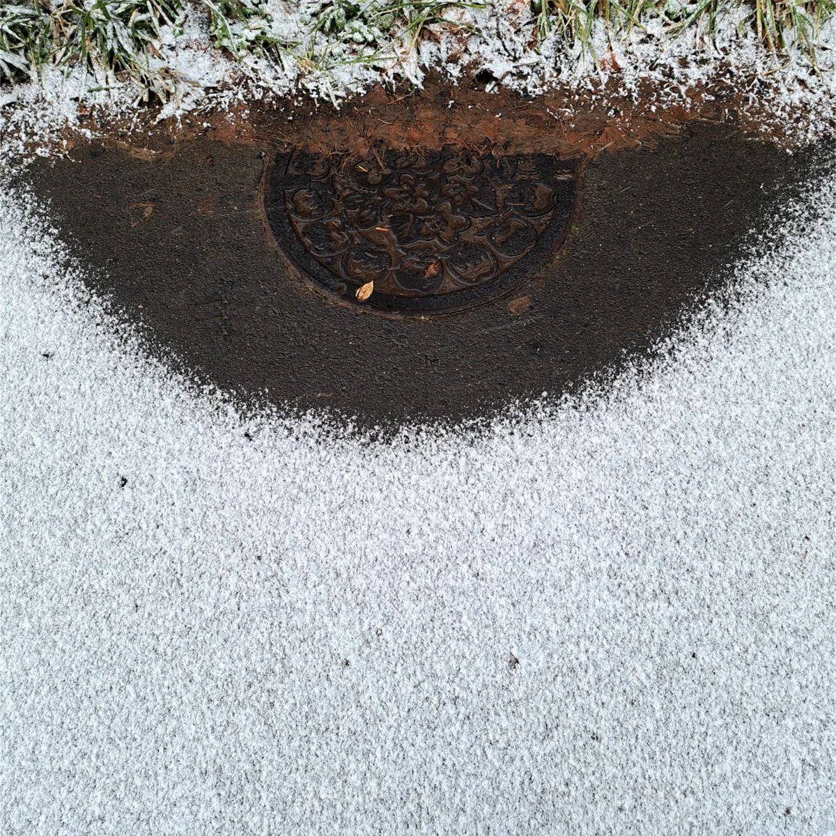 マンホールの周囲だけ雪が溶けている