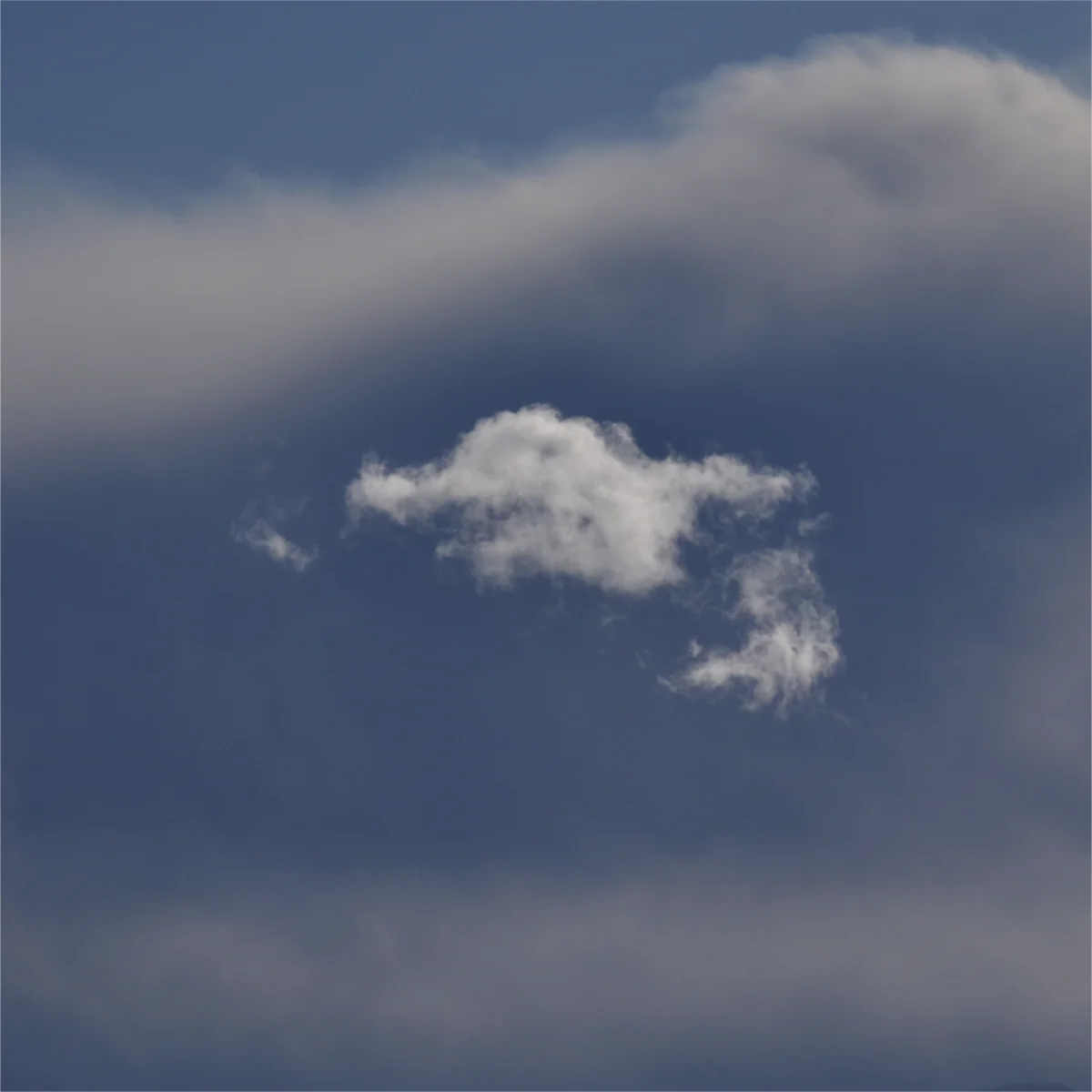 青い雲の前に白い小さな雲が浮いている