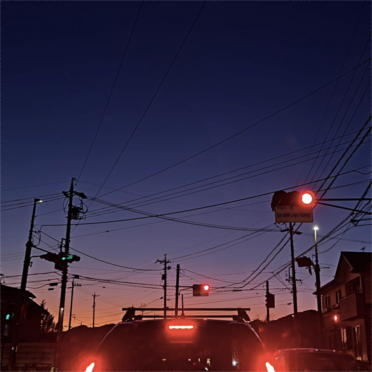 信号の向こうの空が紫色からオレンジ色へのグラデーションを呈している